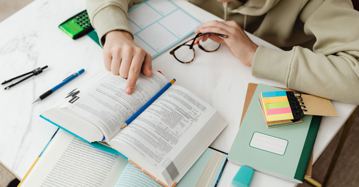 IBCLC exam study tips in action, showing focused review with textbooks, notes, and active studying strategies at a desk.